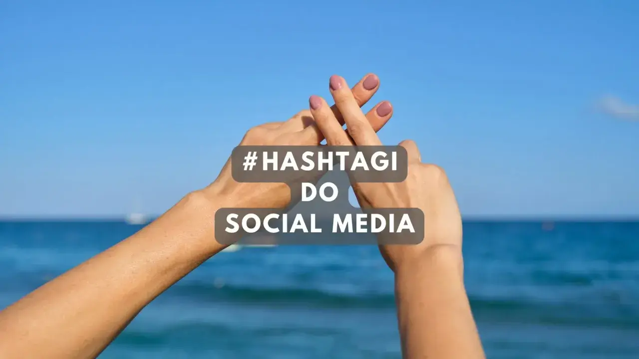 Dwie dłonie tworzą znak #. Tekst: #HASHTAGI DO SOCIAL MEDIA. Idealne gotowe hashtagi na wakacje.