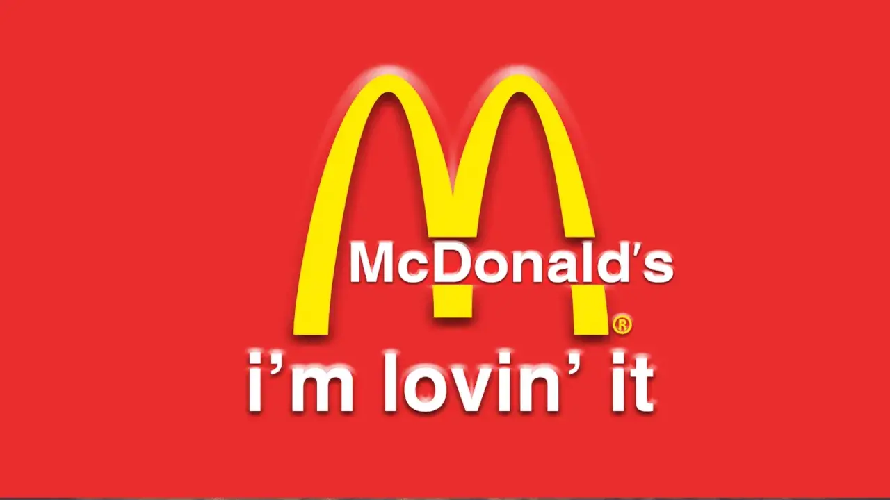 McDonald's "i'm lovin' it" - klasyczne hasła reklamowe przykłady. Złote łuki na czerwonym tle.