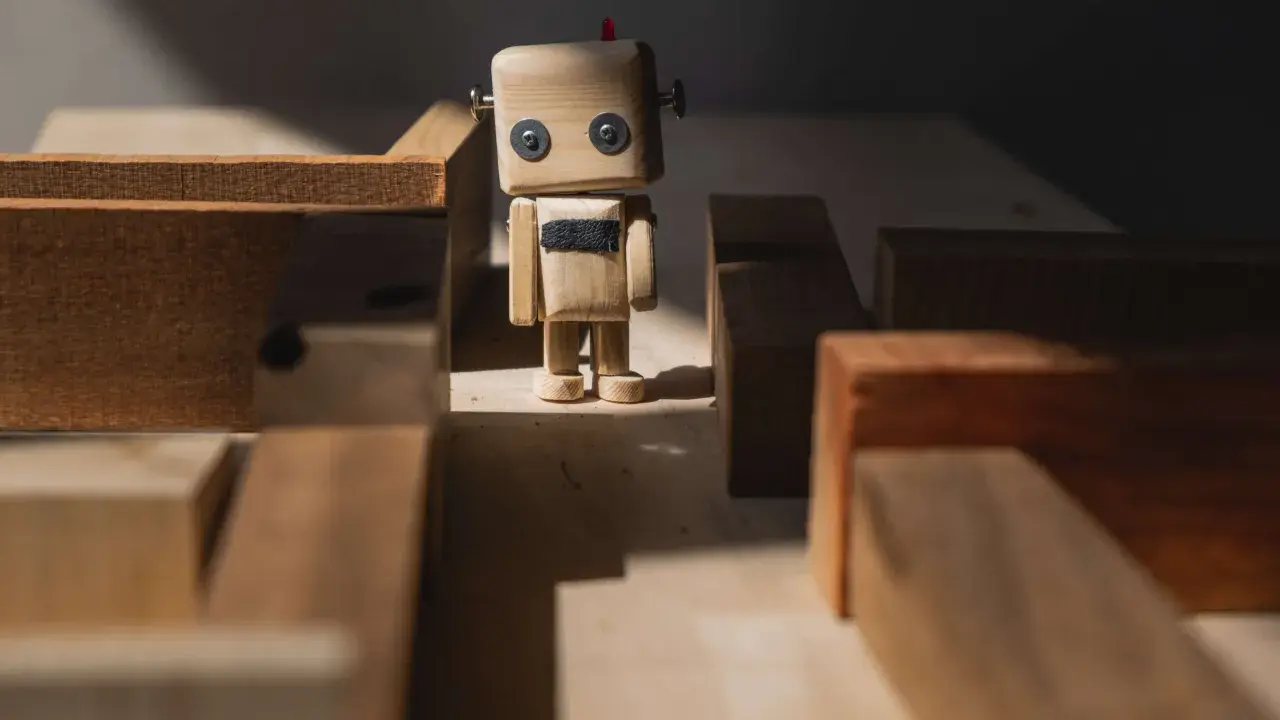 Drewniany robot stoi w labiryncie z klocków, jak zagubione **orphan pages** szukające swojej ścieżki.