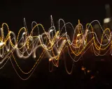 Dynamiczna reklama w postaci falujących linii świetlnych, przypominających ruch uliczny nocą.