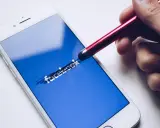 Dłoń z rysikiem próbuje odblokować dezaktywowane konto na FB.