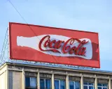 Reklama Coca-Coli, jeden z najbardziej słynnych haseł reklamowych, na tle błękitnego nieba.