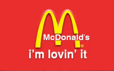 McDonald's "i'm lovin' it" - klasyczne hasła reklamowe przykłady. Złote łuki na czerwonym tle.