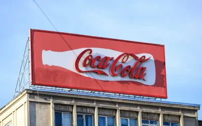 Reklama Coca-Coli, jeden z najbardziej słynnych haseł reklamowych, na tle błękitnego nieba.