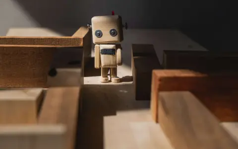 Drewniany robot stoi w labiryncie z klocków, jak zagubione **orphan pages** szukające swojej ścieżki.
