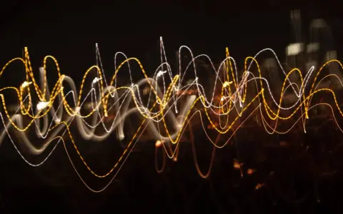 Dynamiczna reklama w postaci falujących linii świetlnych, przypominających ruch uliczny nocą.