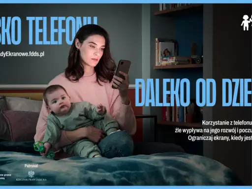 Matka z dzieckiem w reklamie. Kobieta patrzy w telefon, dziecko obok. Przesłanie: ograniczaj ekrany, gdy jesteś z dzieckiem.