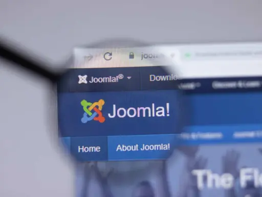 Lupa powiększa logo i nazwę Joomla! na stronie internetowej. Dowiedz się, joomla co to za system CMS.