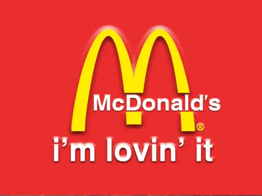 McDonald's "i'm lovin' it" - klasyczne hasła reklamowe przykłady. Złote łuki na czerwonym tle.