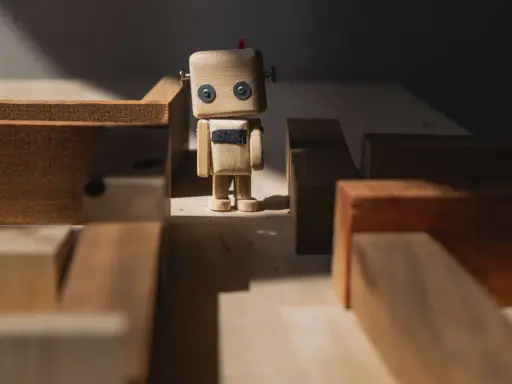 Drewniany robot stoi w labiryncie z klocków, jak zagubione **orphan pages** szukające swojej ścieżki.