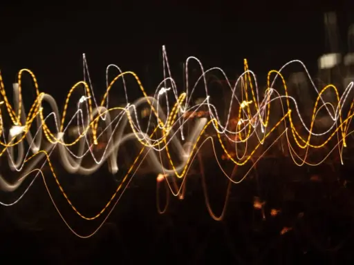 Dynamiczna reklama w postaci falujących linii świetlnych, przypominających ruch uliczny nocą.