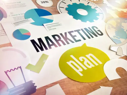 Grafika przedstawia elementy strategii marketingowej: wykresy, żarówkę, globus i napis "MARKETING plan". To wizualizacja skutecznego outbound marketing.