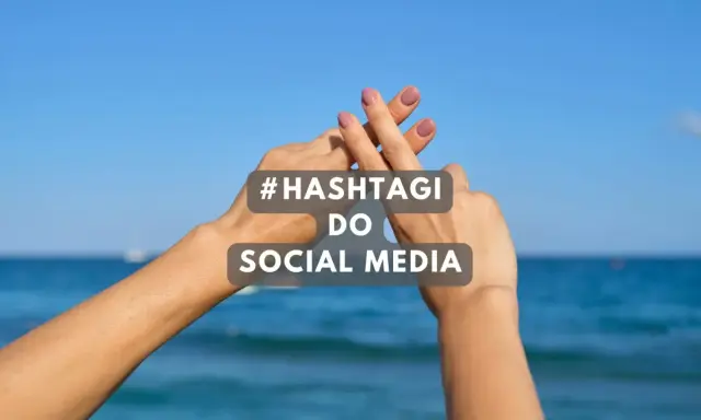 Dwie dłonie tworzą znak #. Tekst: #HASHTAGI DO SOCIAL MEDIA. Idealne gotowe hashtagi na wakacje.