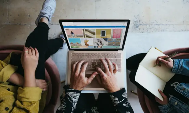 Zespół marketingu realizuje zadania: jedna osoba pisze na laptopie, druga notuje w zeszycie.