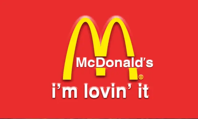 McDonald's "i'm lovin' it" - klasyczne hasła reklamowe przykłady. Złote łuki na czerwonym tle.