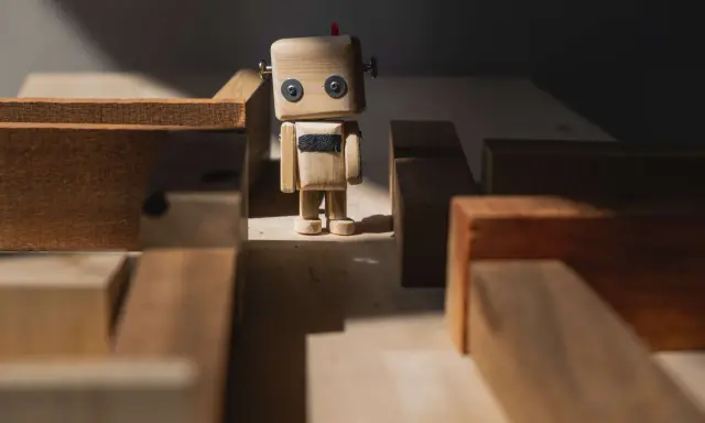 Drewniany robot stoi w labiryncie z klocków, jak zagubione **orphan pages** szukające swojej ścieżki.