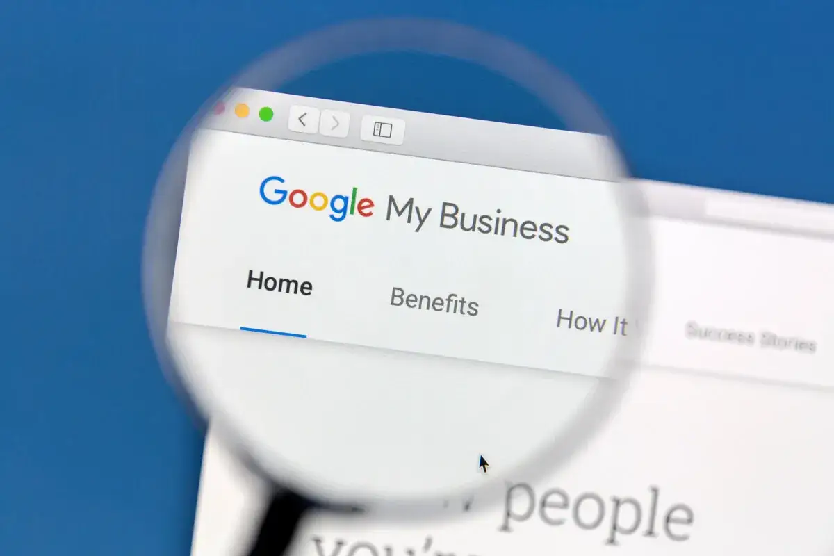 Szukasz informacji, jak zrobić wizyt&oacute;wkę Google? Ekran komputera z panelem Google Moja Firma, powiększony lupą.