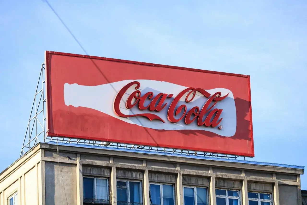 Reklama Coca-Coli na dachu budynku. Choć nie ma tu śmiesznych haseł reklamowych, sama butelka i logo budzą pozytywne skojarzenia.