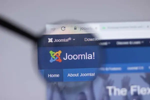 Lupa powiększa logo i nazwę Joomla! na stronie internetowej. Dowiedz się, joomla co to za system CMS.